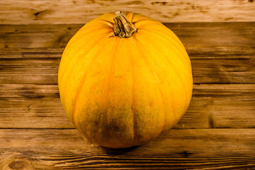 Ripe orange pumpkin on the wooden table