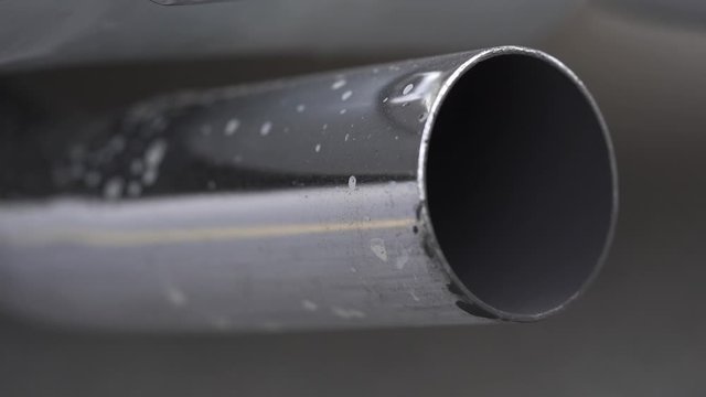 Vehicle chrome metallic exhaust pipe close-up.