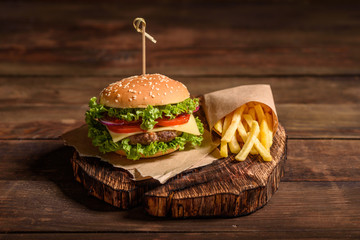 Tasty grilled homemade burger with beef, tomato, cheese, cucumber and lettuce. Delicious grilled...