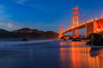 Golden Gate Bridge view from the hidden and secluded rocky Marshall's Beach at sunset in San Francisco, California