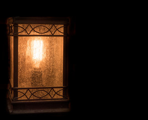 Vintage lantern in darkness. Light concep on black background