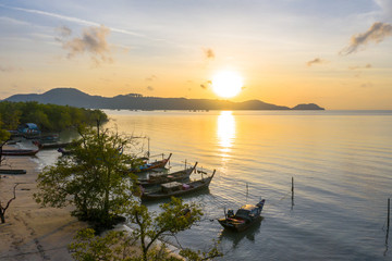 Obraz premium aerial view sunrise above fishing boats parking near the beach.