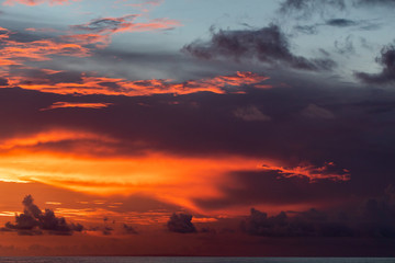 Majestic colorful tropical sunset. Amazing red, orange, pink clouds. Tropical background.