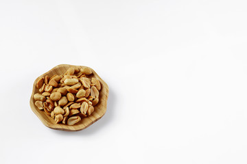 wood plate of salted peanuts isolated on white background.