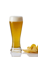 Perfect glass of beer with foam and potato chips on white background