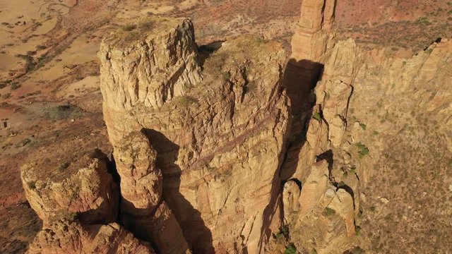 Tilting drone shot of steep mountain cliff, location of small monolithic church of Abuna Yemata Guh in the Tigray region of Ethiopia