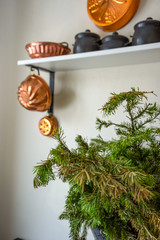 Closeup antique antique aged copper utensils, pots, pans hanging on white wall at home. Concept decor at country castle, chateau, tenuta