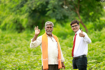 Indian Farmer and Agronomist showing thumps up in Green Cotton Field 