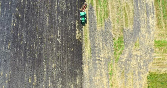Aerial view drone of harvest field with tractor mows dry grass. Autumn yellow field with a haystack after harvest top view. Harves. Ting in the fields. 