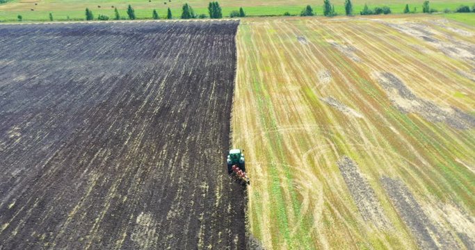 Aerial view drone of harvest field with tractor mows dry grass. Autumn yellow field with a haystack after harvest top view. Harves. Ting in the fields. 
