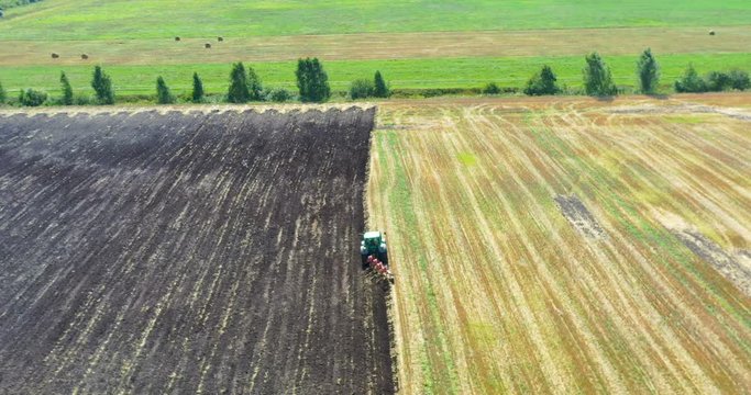 Aerial view drone of harvest field with tractor mows dry grass. Autumn yellow field with a haystack after harvest top view. Harves. Ting in the fields. 