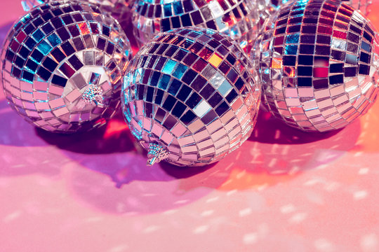 New year baubles. Shiny gold disco balls on neon background. Pop disco  style attributes, retro Stock Photo by jchizhe