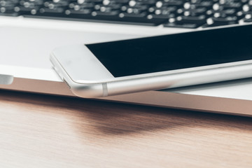 Laptop and mobile phone on the table. Workspace concept.