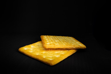 Cracker cookies on dark background.