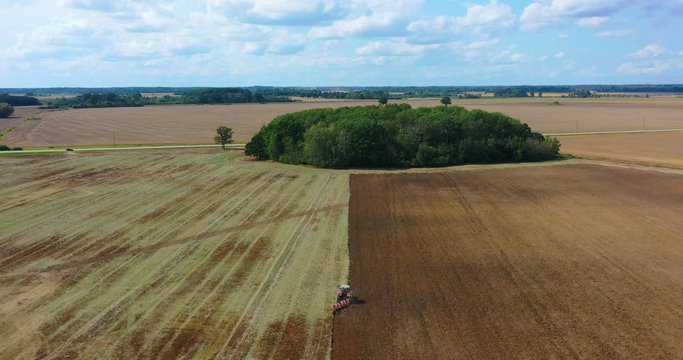 Aerial view drone of harvest field with tractor mows dry grass. Autumn yellow field with a haystack after harvest top view. Harves. Ting in the fields. 