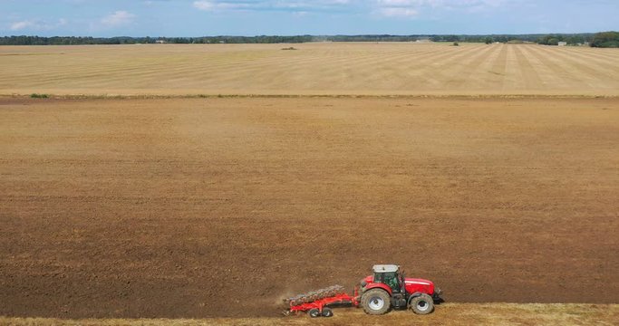Aerial view drone of harvest field with tractor mows dry grass. Autumn yellow field with a haystack after harvest top view. Harves. Ting in the fields. 
