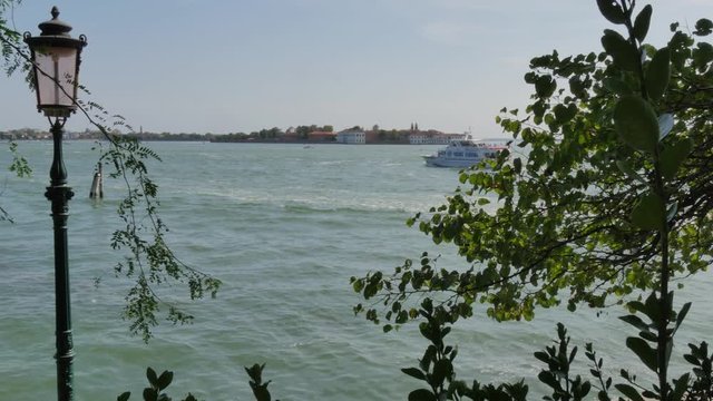 ferry boat sails along Giudecca Canal, view from Venice Art Biennale
