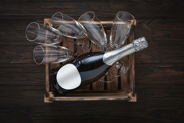 champagne bottle and empty glasses in a box on a wooden background. Concept: Big party, bachelor party. hen party, graduation.