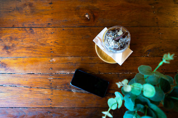 iced coffees and phone flat laid on a textured wooden table