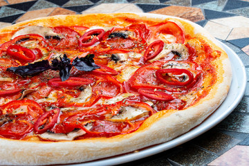 Diabola pizza with chorizo and chili. Spicy dish. On the stone table