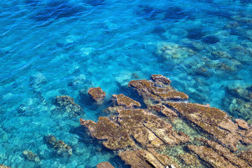 Naklejka na ściany i meble Tyrrhenian coast in Sicily, Cefalu. Bright blue deep sea with big stone in water. Natural background or seascape.
