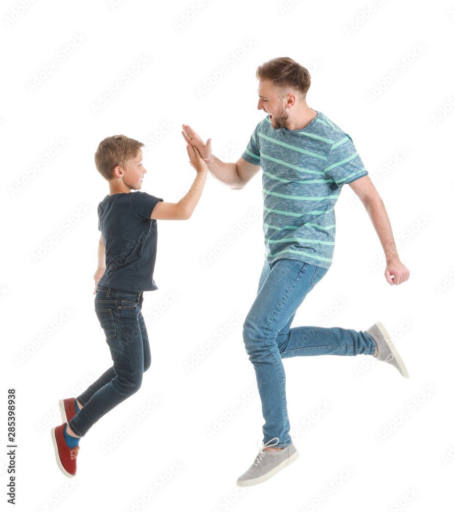 Poster Jumping father and son giving each other high-five on white background