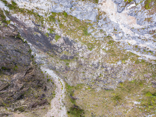 landscape of the valley of a mountain hill flooded with light and covered with large stones of different shapes with moss of green yellow and brown, rock space, a fresh summer day under the blue sky