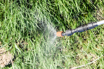 Spraying herbicide from the nozzle of the sprayer manual