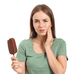 Young woman with sensitive teeth and cold ice-cream on white background