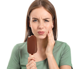 Young woman with sensitive teeth and cold ice-cream on white background