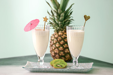 Glasses of tasty Pina Colada cocktail and pineapple on table