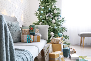 Interior of room with Christmas tree, sofa and many gifts