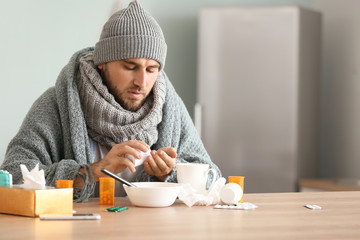 Sick man taking medicine at home