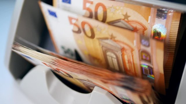 Many printed banknotes in a counting machine.