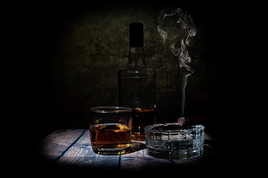 glass of wihisky and cigar on black background