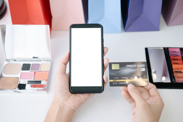 Mockup image of Beautiful woman holding credit card shopping online with smartphone on online websites, mockup concept