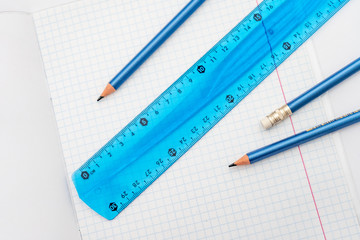 open school notebook with a simple pencil and a ruler on a white table. back to school