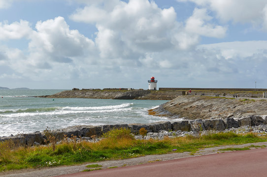 Burry Port Breakwater and Lighthouse at the small old Coal harbour, now used for recreation, with small waves coming on to the beach. Wales.