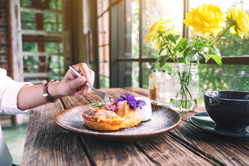A hand cutting a piece of coconut pie with a beautiful decoration in a plate to eat by fork