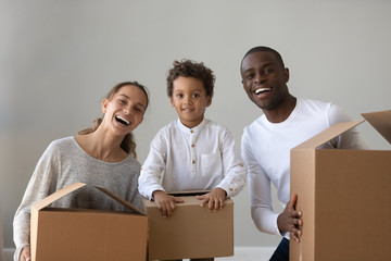 Happy african american family renters hold boxes looking at camera