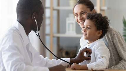 African male pediatrician hold stethoscope exam child boy patient - obrazy, fototapety, plakaty