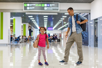 father and little daughter walking in the airport, family travel