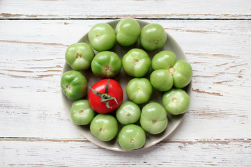 green tomatoes,pickles background on white wooden table with green and red and chilli peppers,fennel,salt,black peppercorns,garlic,pea,close up,healthy concept,top view,flat lay