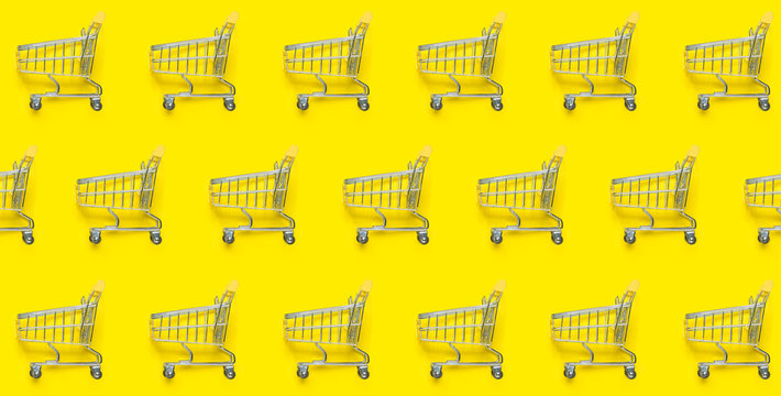 Shopping trolley on a yellow background. Pattern. Flat lay, top view