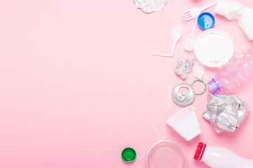 Garbage collection, plastic and metal on a pink background. Concept stop plastic, recycling, separate collection of garbage. Flat lay, top view