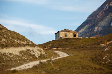 Fototapeta na wymiar Photo of house at foot of mountain, picturesque mountain area and cloudy sky