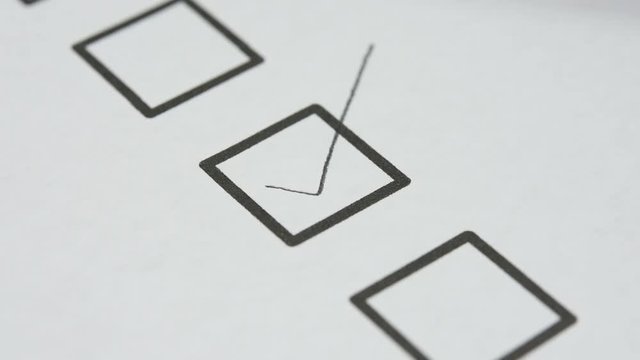 pencil make a check mark sign in check box do to list on white paper, closed up and selective focus