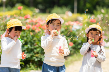 公園で遊ぶ保育士と園児たち