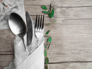 Festive place setting for christmas dinner. Vintage cutlery on the white napkin and fir cone,...