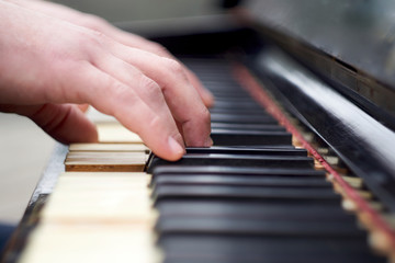 Fototapeta premium Closeup shot of male hands on the piano keyboard.